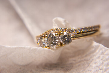 Sparkly Gold Diamond Wedding Ring Jewelry on White Textured Background