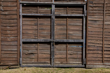 木板の壁と鉄枠の門扉