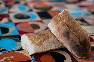 primer plano de pan casero en panera sobre mesa y mantel de colores