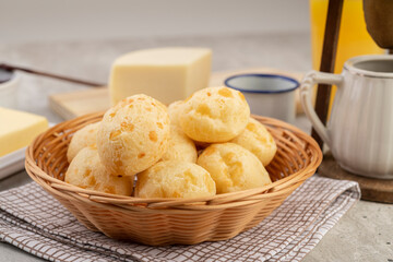 Typical brazilian cheese bun in a bowl, coffe, butter and orange juice