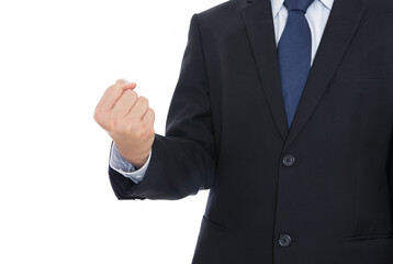 A business man in a black suit stretches out his hand to make a fist gesture in front of white...