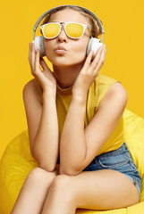 Gorgeous blonde hipster girl wearing sunglasses enjoys the music