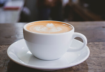 cup of hot latte coffee on wooden table