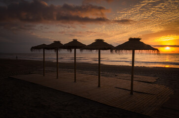 Colorful sunset among umbrellas on the beach