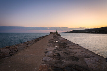 Breakwater at the entrance to the harbor of Peniscola at sunset, Castellon, Spain