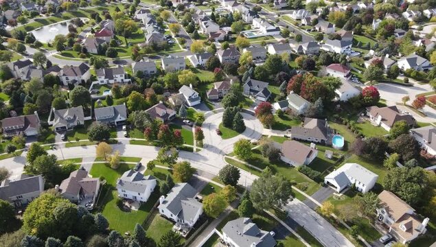 Overhead aerial view of colorful autumn trees residential houses and yards along suburban street in Chicago area. Midwest USA