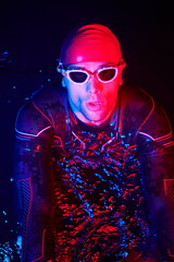 Obraz premium authentic triathlete swimmer having a break during hard training on night neon gel light