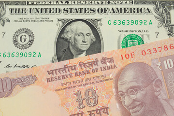 A macro image of a orange ten rupee bill from India paired up with a green one dollar bill from the United States.  Shot close up in macro.