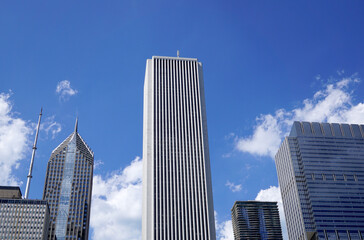 Fototapeta na wymiar Downtown, Tall light building in the center. Blue sky with white clouds behind