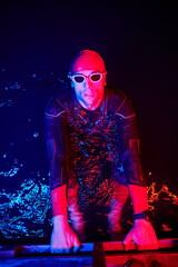authentic triathlete swimmer having a break during hard training on night neon gel light