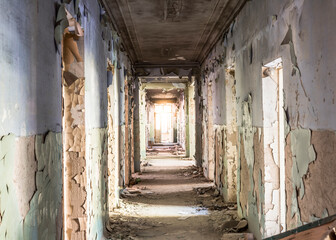 Corridor in an abandoned building on the ruins. Light at the end of the corridor