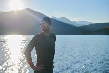 triathlon athlete starting swimming training on lake