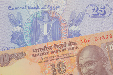 A macro image of a orange ten rupee bill from India paired up with a blue twenty five piastre bank note from Egypt.  Shot close up in macro.