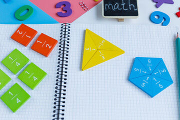 Multicolored math fractions, open notebook, numbers on blue pink white background. Interesting, fun mathematics for kids, preschooler. Education, back to school concept