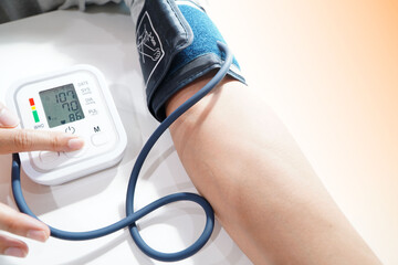 Monitoring blood pressure of patients using upper arm blood pressure monitor in the clinic examination room.
