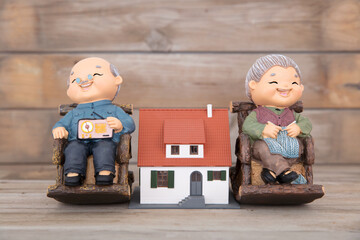 Old couple sculpture a small house model in the middle
