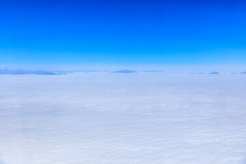 Aerial view above the clouds and mountain peaks on a sunny day.mountain view from airplane.