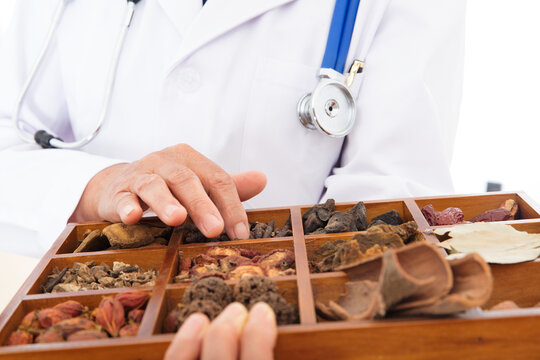 Close-up shot of a doctor holding a Chinese medicine box with his hand touching it
