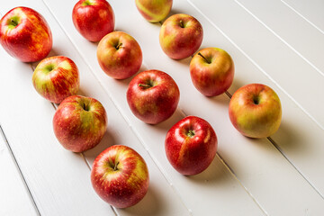 Fresh apples on a white wooden background.