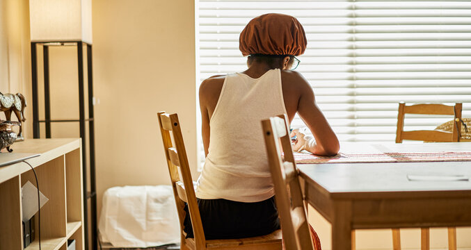 african american woman wearing showercap looking at smartphone during morning routine