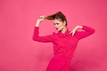 Portrait of a red-haired woman in bright clothes on a pink background cropped view of gesturing with her hands