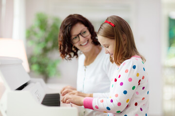 Child playing piano. Kids play music.