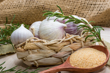 Preserved Garlic with fresh herbs on vintage background