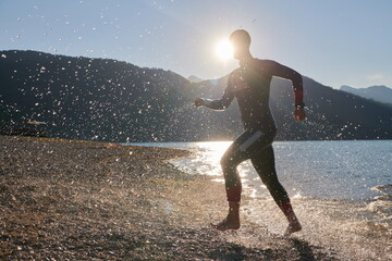 triathlon athlete starting swimming training on lake