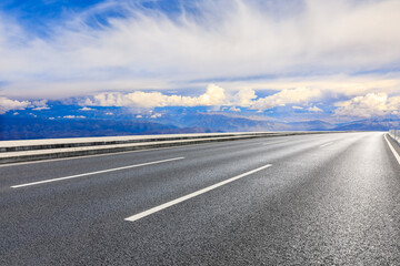 Asphalt road and mountain with sky clouds landscape.