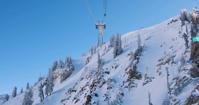Aerial Tram from the foot of the hill to the top of Hidden Peak in winter at Snowbird in Little Cottonwood Canyon in the Wasatch Range near Salt Lake City, Utah, USA. Snow-covered mountain & forest.