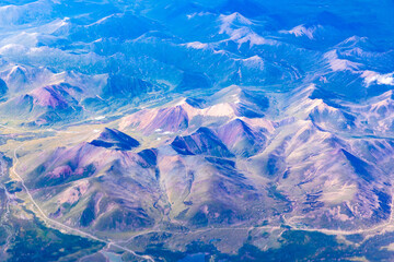 Obraz premium Aerial view above the clouds and colorful mountain on a sunny day.mountain view from airplane.