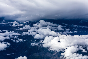 Aerial view above the clouds and mountain peaks on a sunny day.mountain view from airplane.