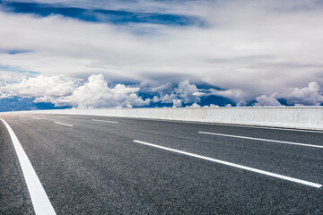 Asphalt road and mountain with sky clouds landscape.