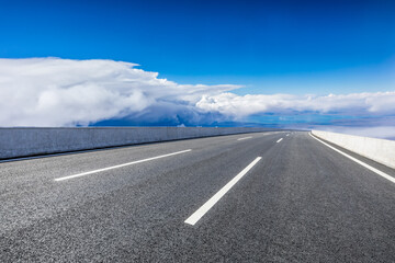 Empty asphalt road and blue sky with white clouds scenery.