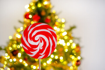 Christmas and New Year. Lollipop.New year and christmas candy. Red striped lollipop on shining tree...