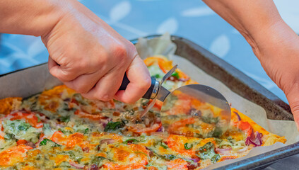 Woman cutting homemade pizza. Selective focus, close up, concept photo food.