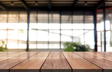 Empty wooden table top with lights bokeh on blur coffee shop background.