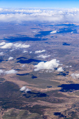 Fototapeta premium Aerial view above the clouds and mountain peaks on a sunny day.mountain view from airplane.