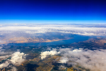 Obraz premium Aerial view above the clouds and mountain peaks on a sunny day.mountain view from airplane.