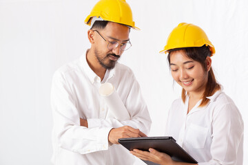 Pretty Architect and Young Engineer in construction helmets talking and discussing, Using Digital Tablet Computer, Working together with isolated on white background.