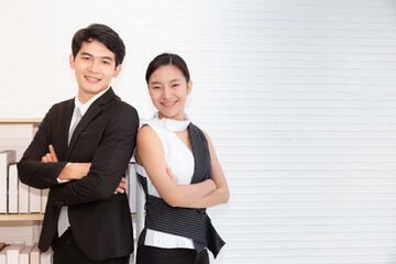 Young couple business man and business woman standing back to back with crossed hands against white background. Partnership in business and Black&White fashion concept.