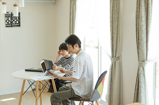 テレワークをする父親とタブレットPCを見る男の子