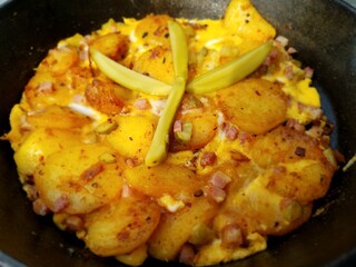 Hüttenessen in einer gusseisernen Pfanne - Bratkartoffeln, Bauernfrühstück mit Gurke