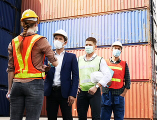 Young woman engineers standing in the shipping yard tracking the cargo inventory and checking...