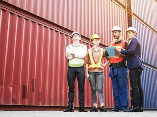 Young woman engineers standing in the shipping yard tracking the cargo inventory and checking...