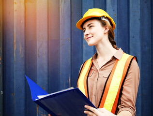 Young woman engineers standing in the shipping yard tracking the cargo inventory and checking...