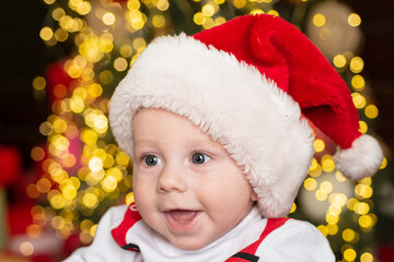 Christmas portrait of happy little baby in santa hat.