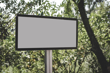  Blank board in a lush green trees park