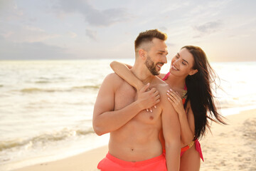 Happy young couple on beach on sunny day