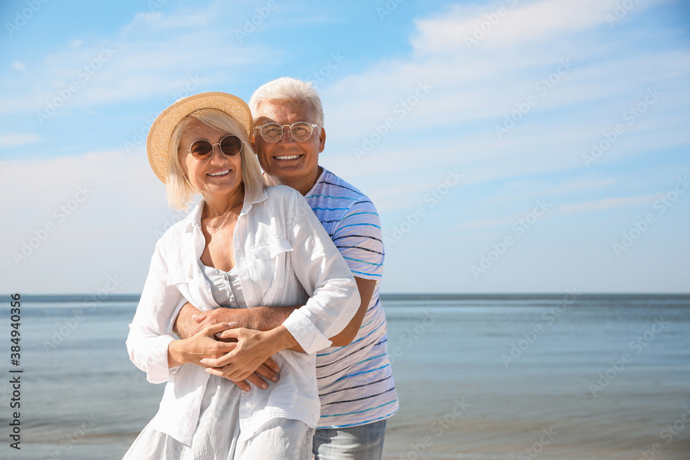 Wall mural Mature couple spending time together on sea beach